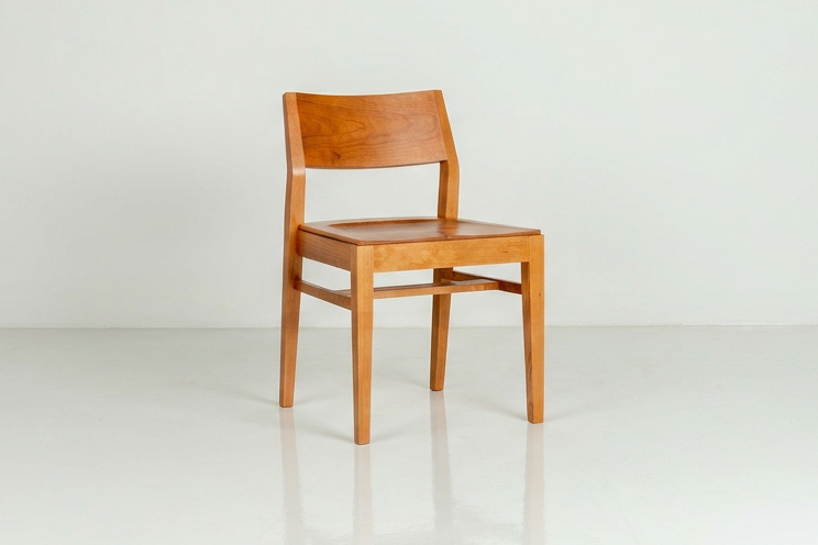 Wooden chair on a white floor with a white wall background