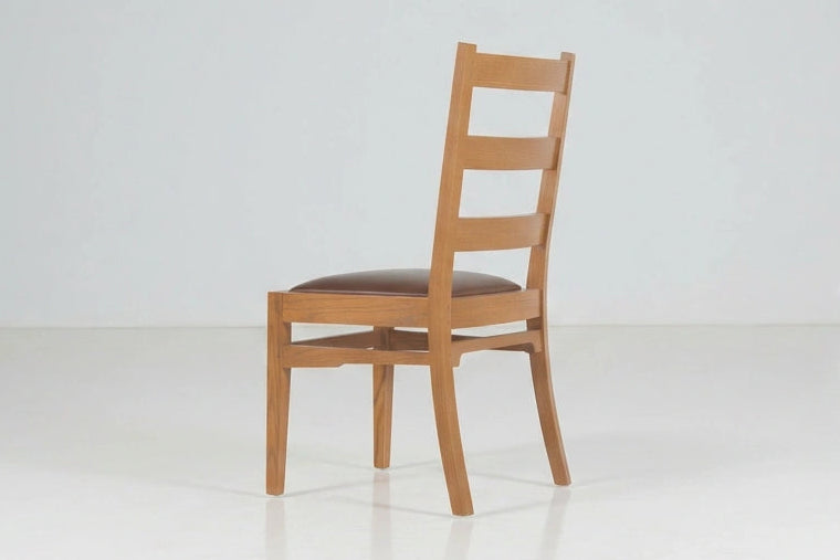 Back angle of a wooden chair on a white background.