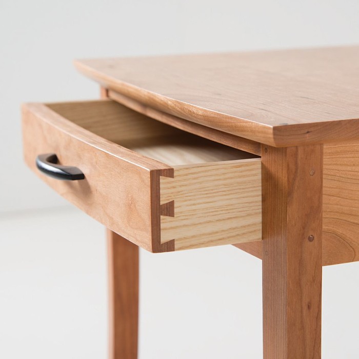 crescent side table in cherry showing the dovetail joinery of the drawer