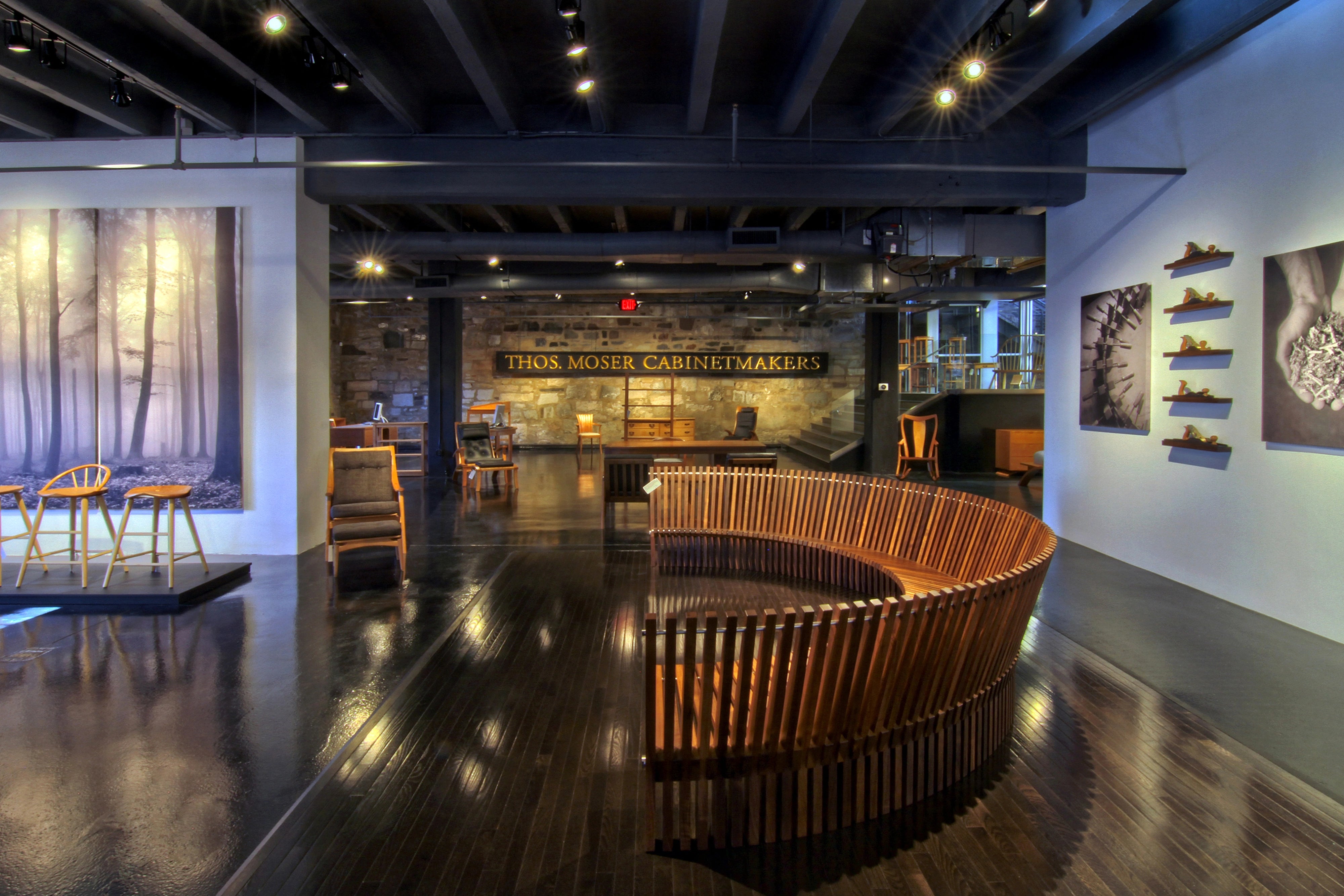 Wooden furniture display in a showroom with 'Thor Moger Cabinetmakers' sign.