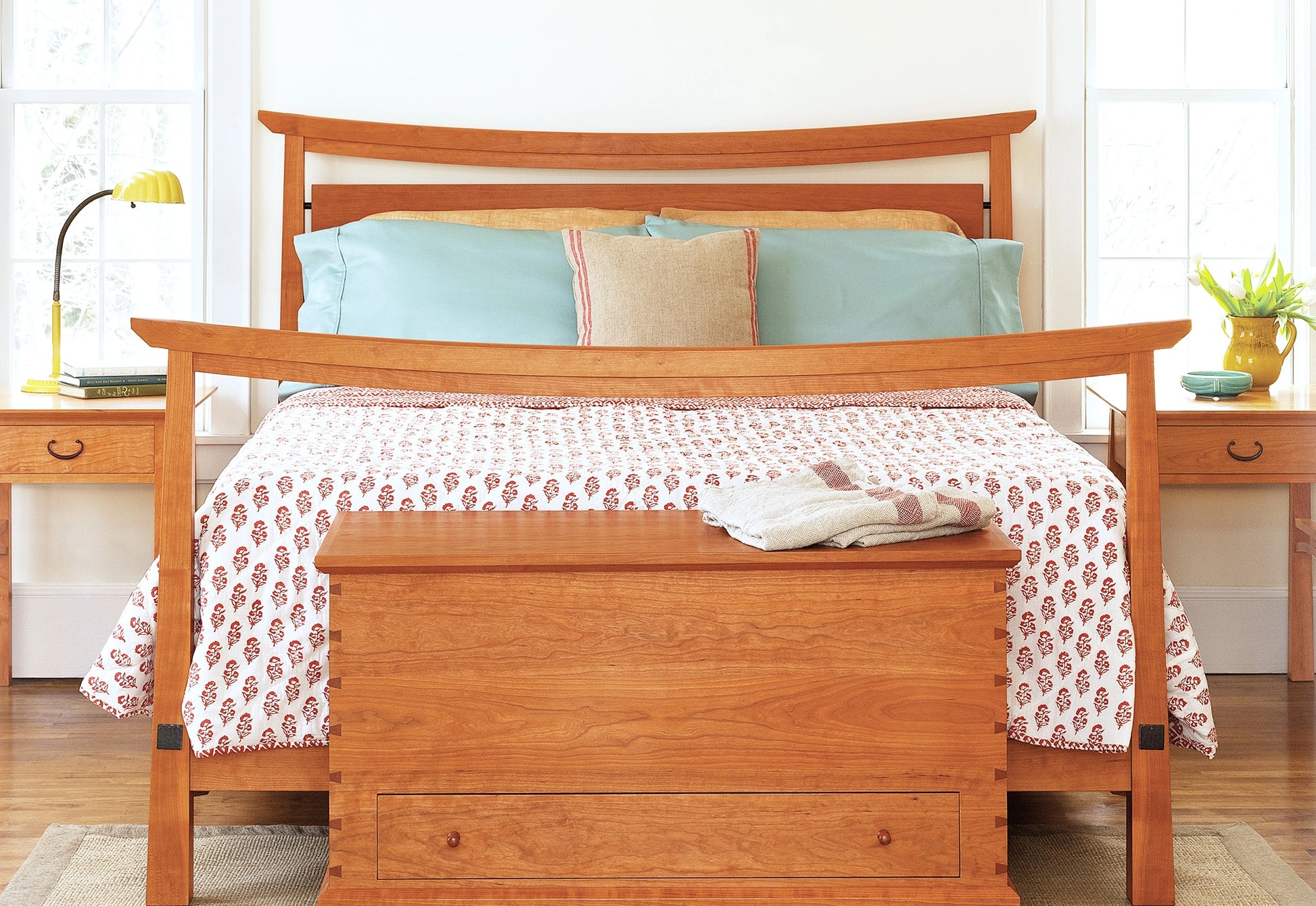 Bungalow style bed in cherry wood in a bright room.