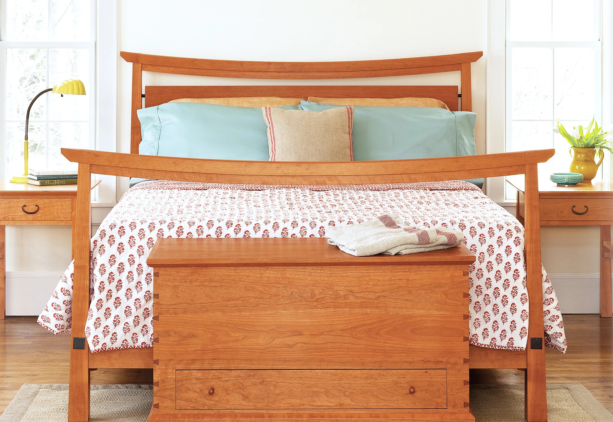 Bungalow style bed in cherry wood in a bright room.