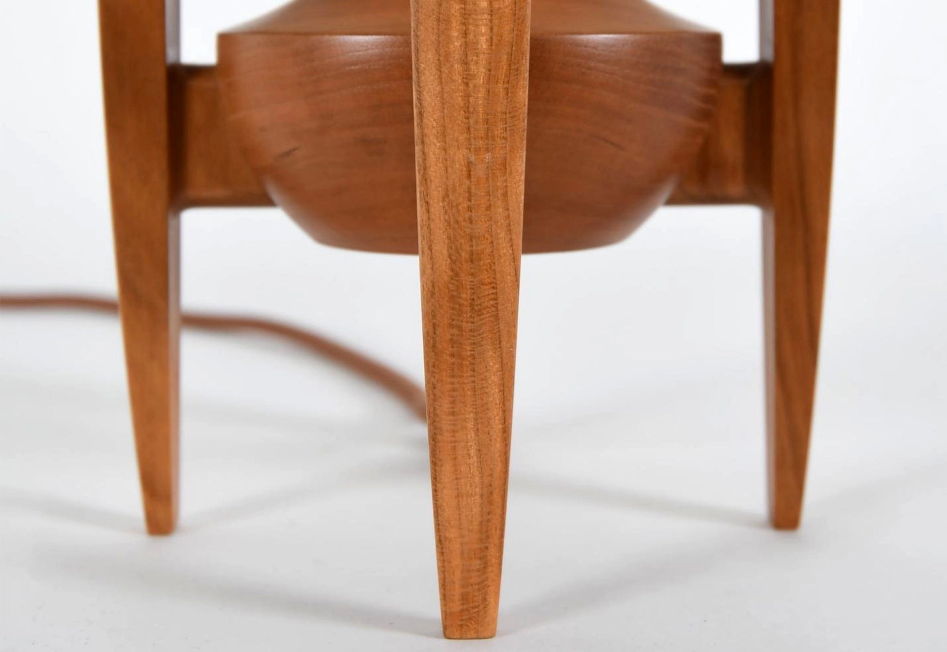 Wooden lamp with a focus on the leg and seat detail against a white background