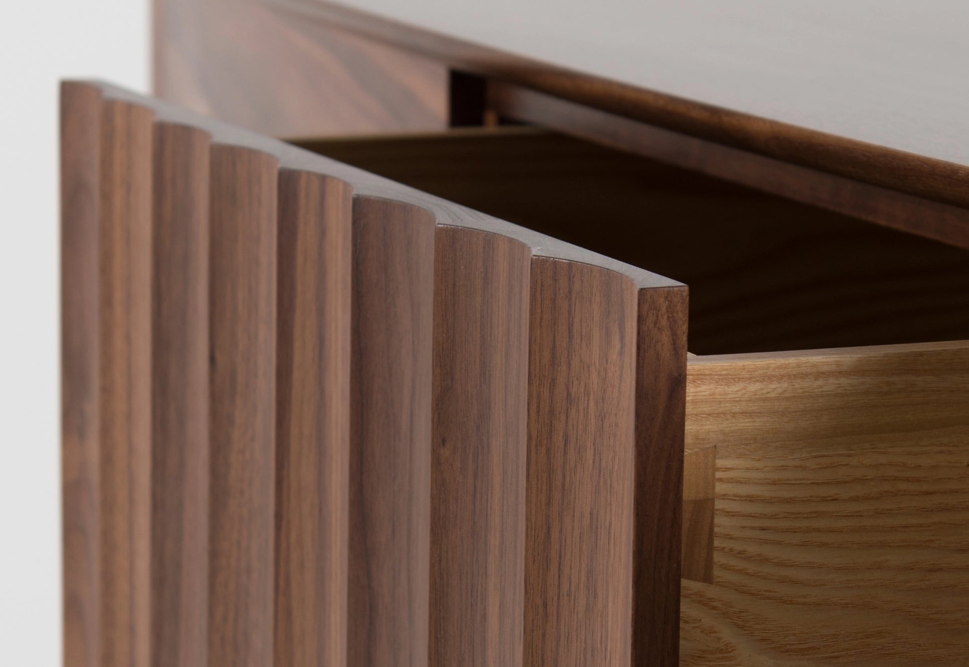 Close up of a wooden sideboard with drawers on a white background