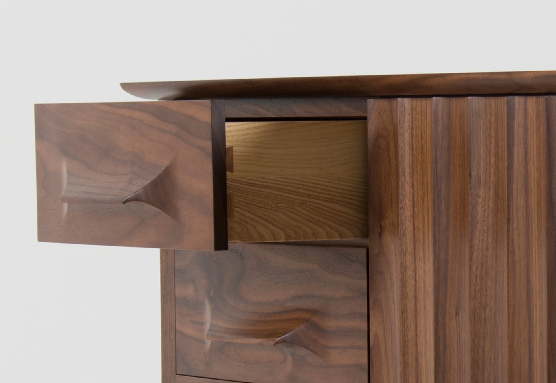 Close-up of a wooden sideboard with a focus on the drawer and door design.
