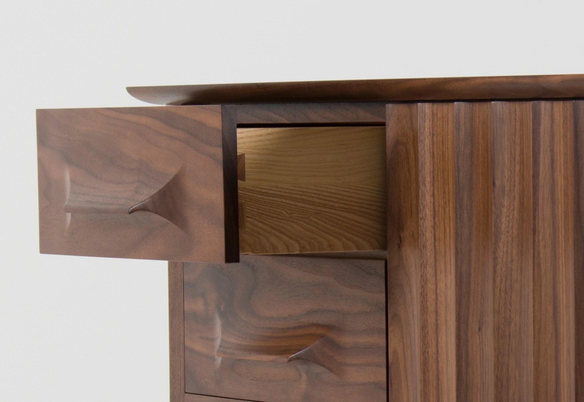 Close-up of a wooden sideboard with a focus on the drawer and door design.