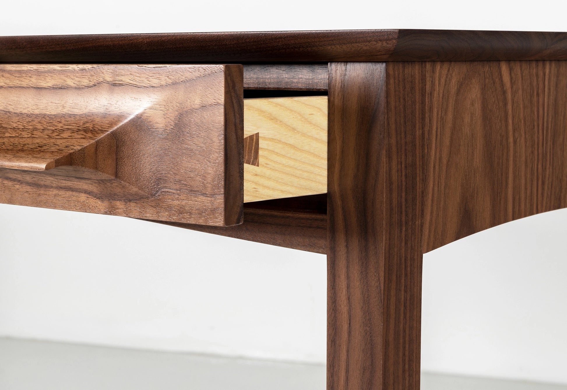 Wooden desk with a drawer open on a white background