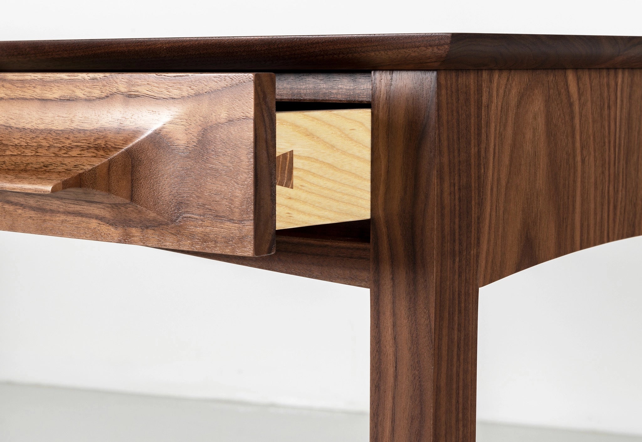 Wooden desk with a drawer open on a white background