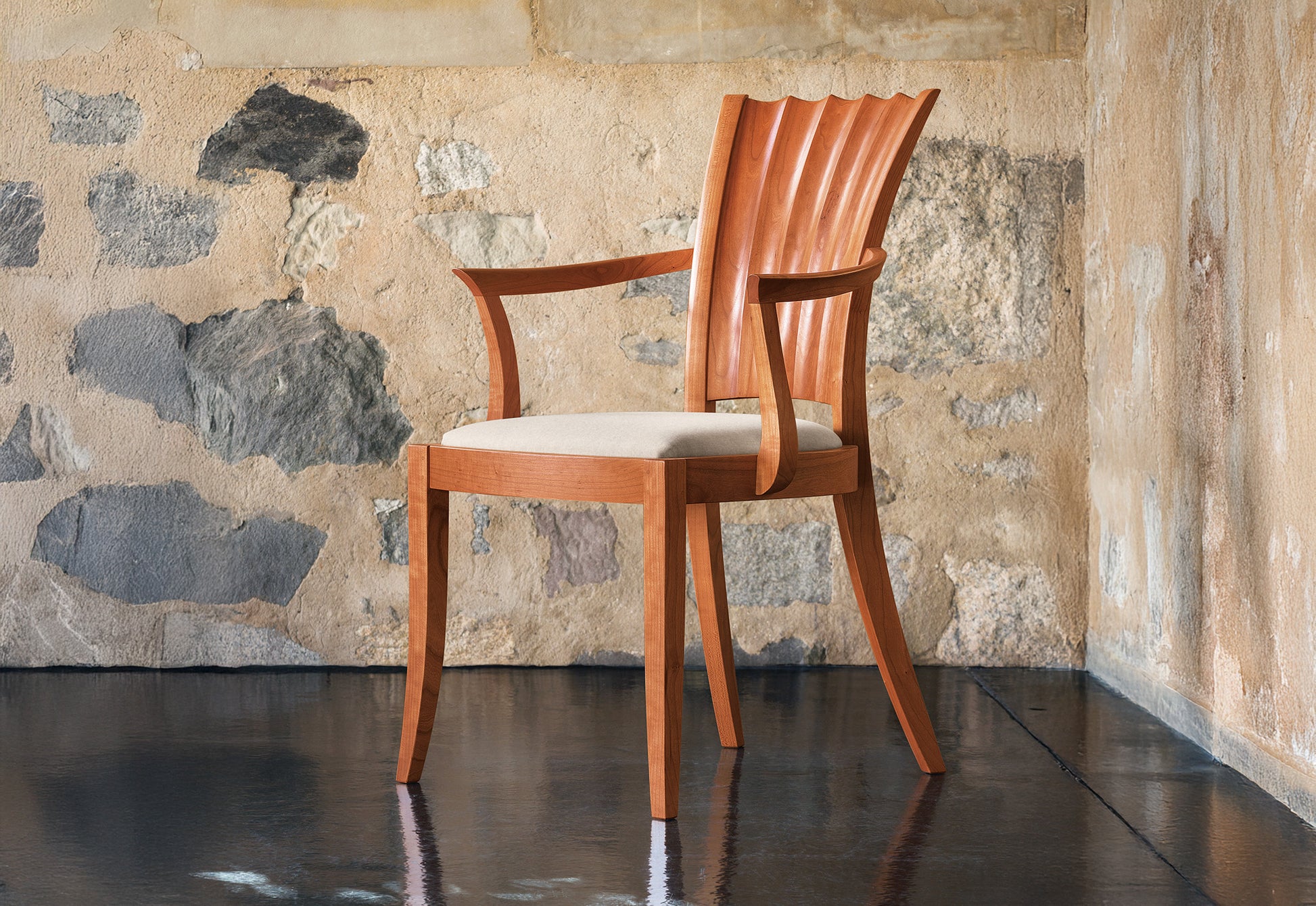 Wooden chair with a textured stone wall background