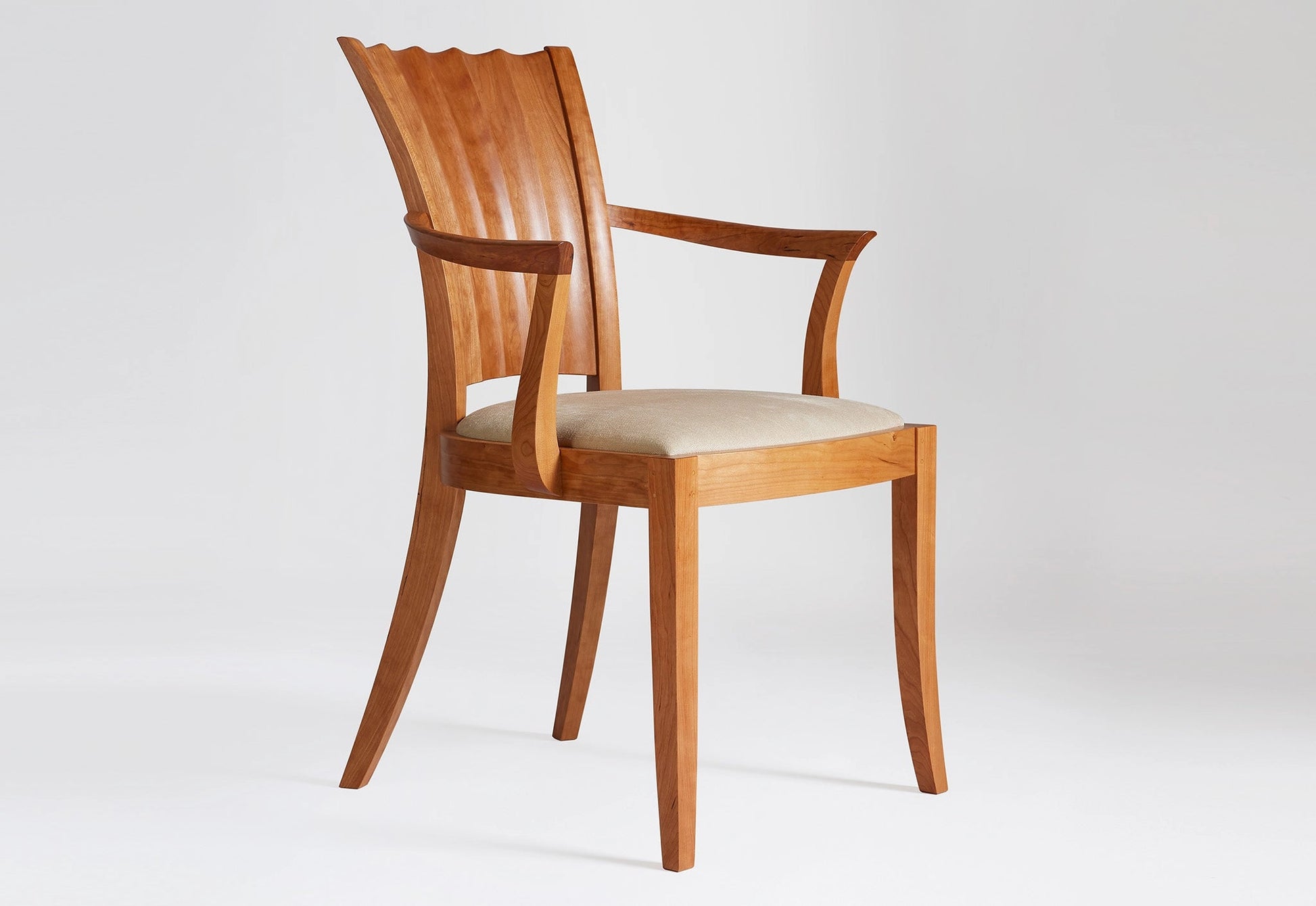 Wooden chair with a white cushion on a light gray background