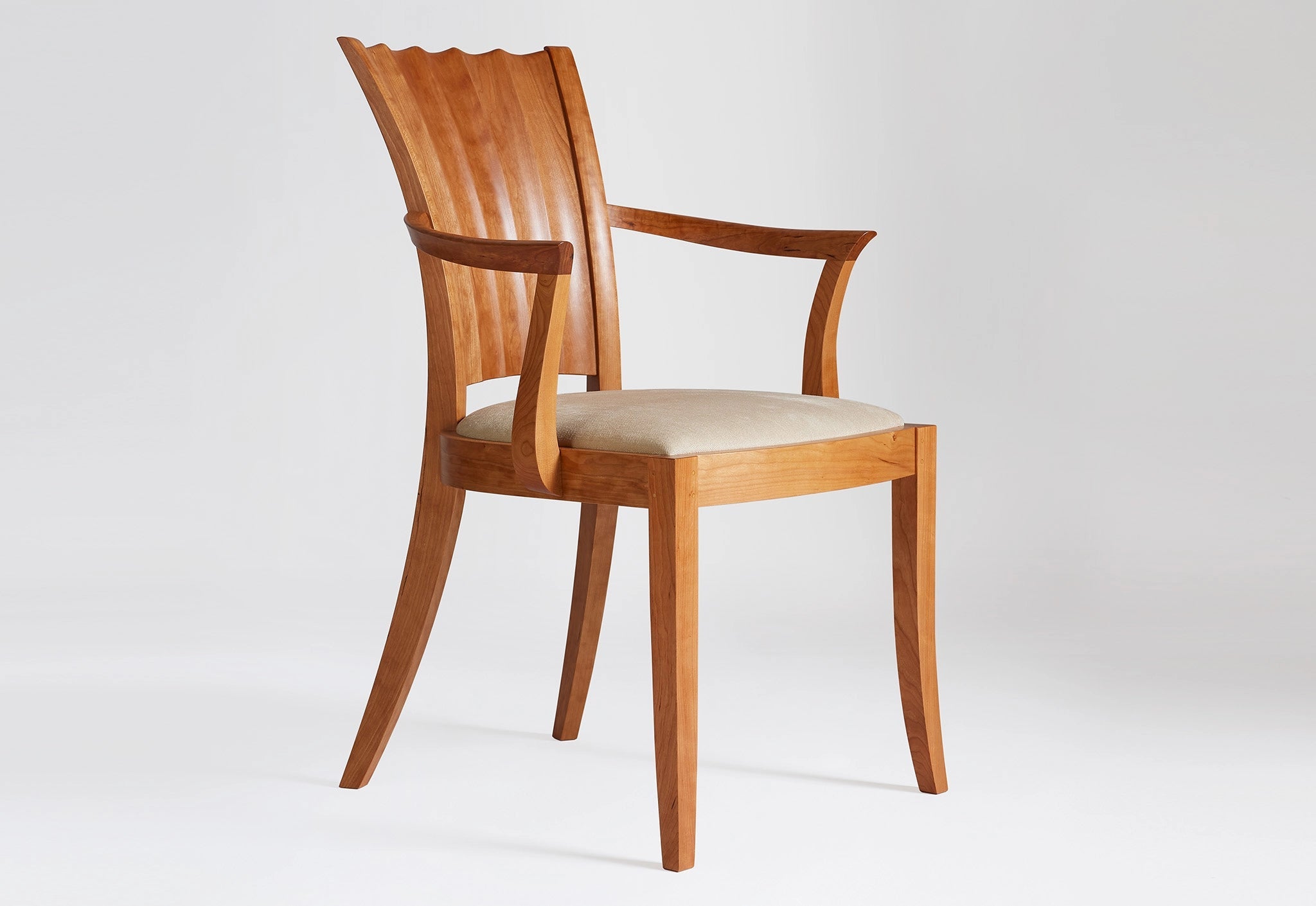 Wooden chair with a white cushion on a light gray background