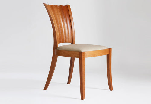 Wooden chair with a beige cushion on a white background