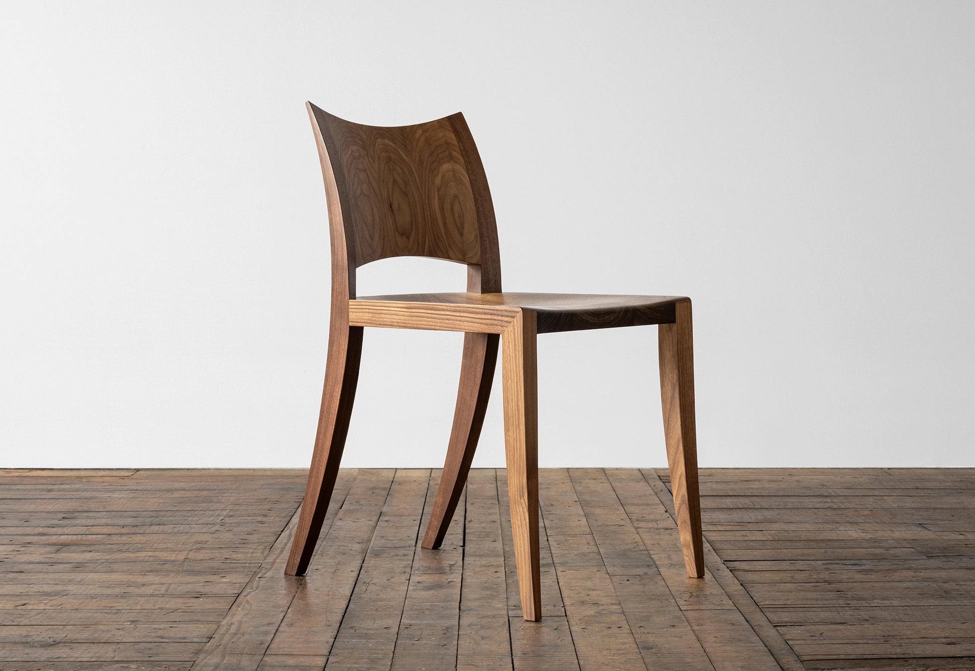 Wooden chair on a wooden floor with a white wall background