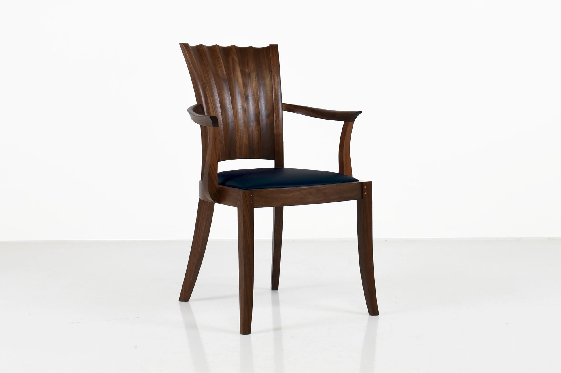 Wooden chair with a black cushion on a white background