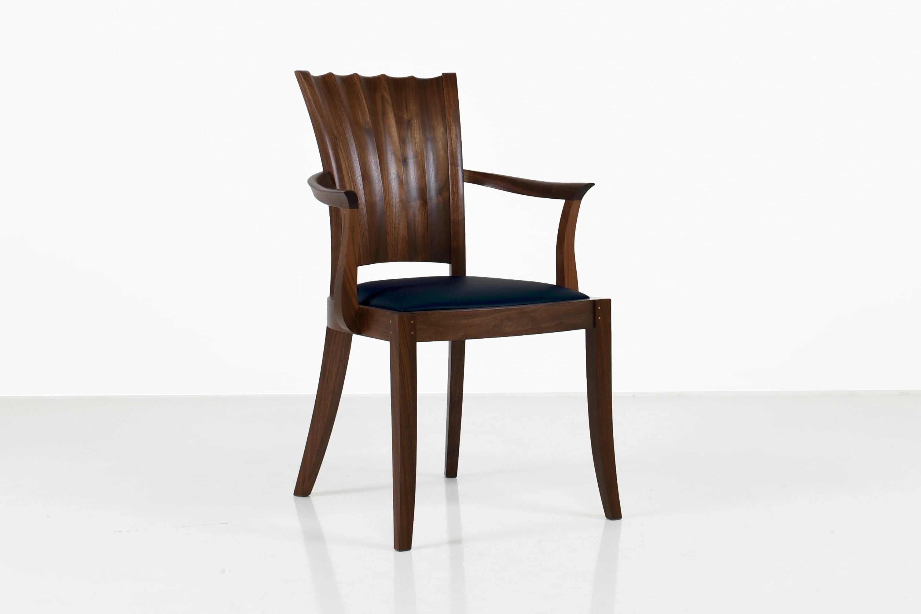 Wooden chair with a black cushion on a white background