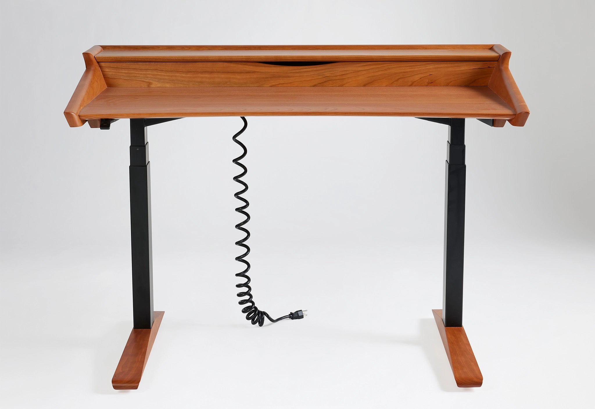 Wooden standing desk with black cable on a white background