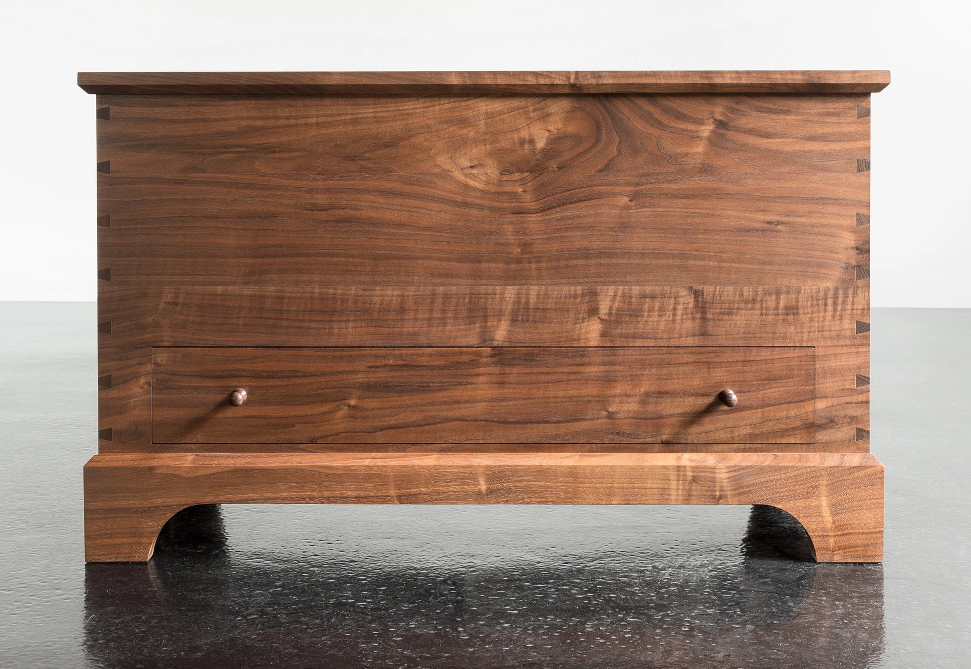 Wooden chest on a reflective surface with a white background