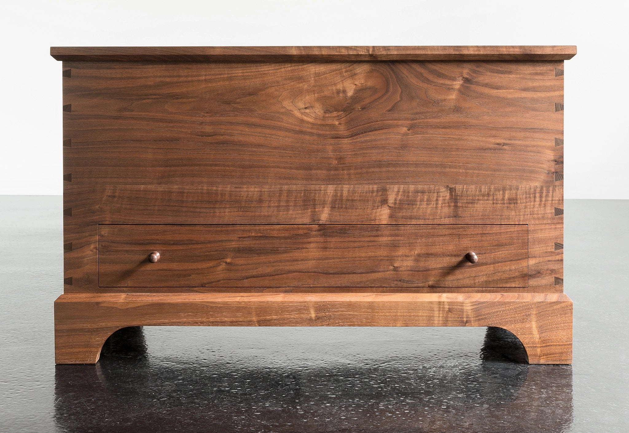 Wooden chest on a reflective surface with a white background