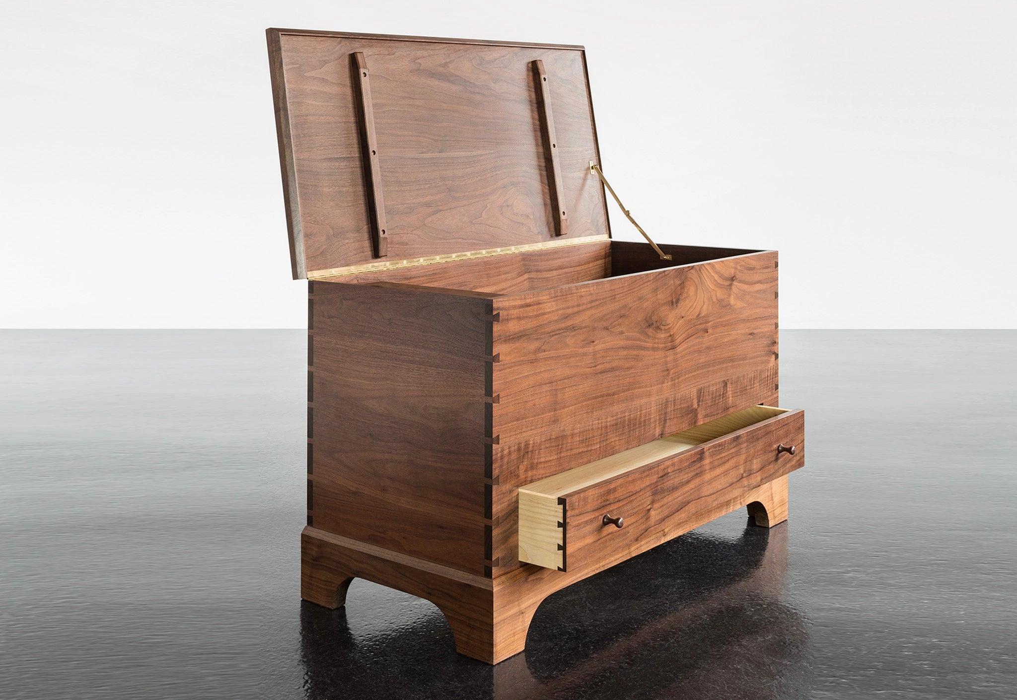 Wooden storage chest with a drawer on a reflective surface
