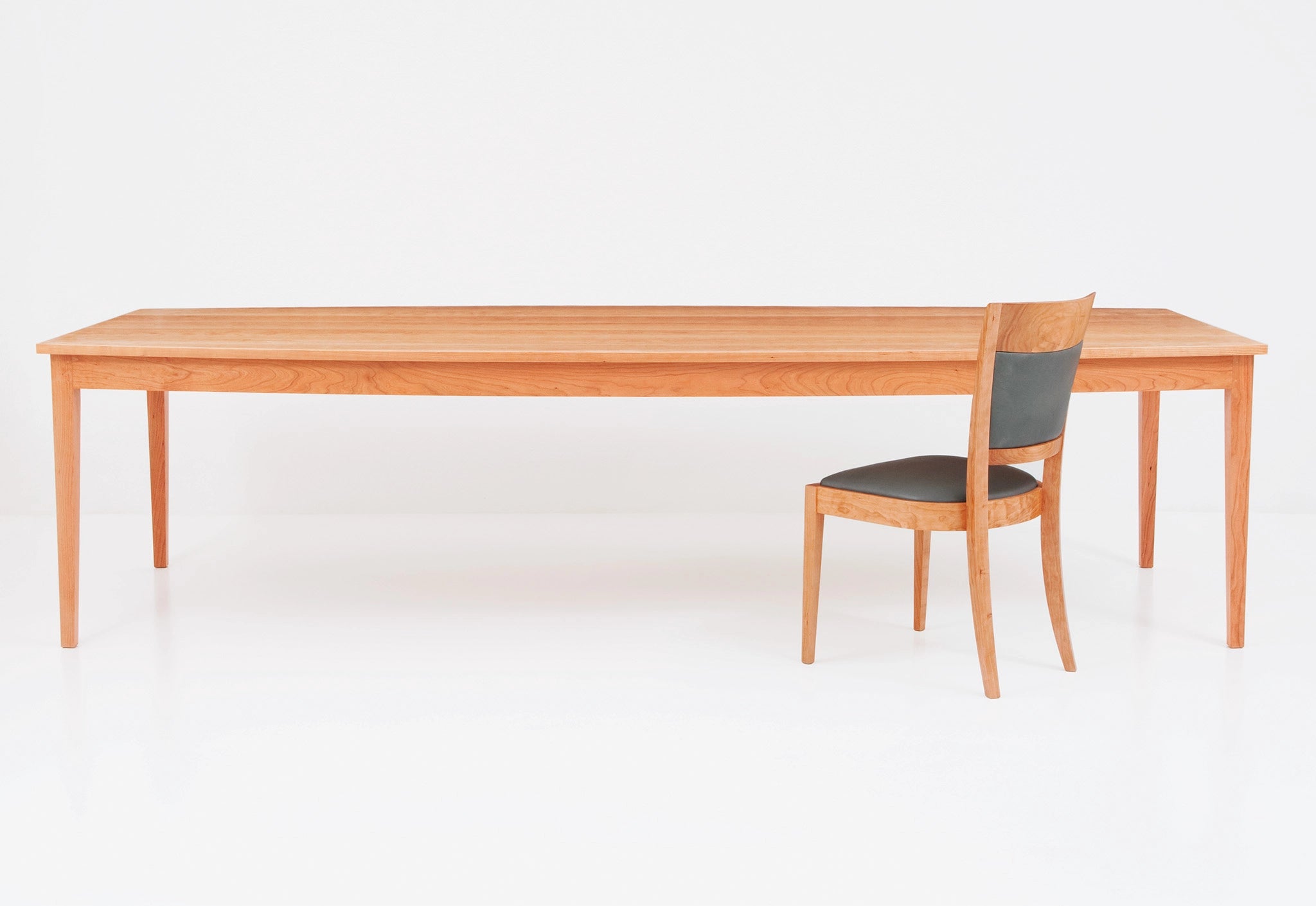 Wooden dining table with a chair on a white background