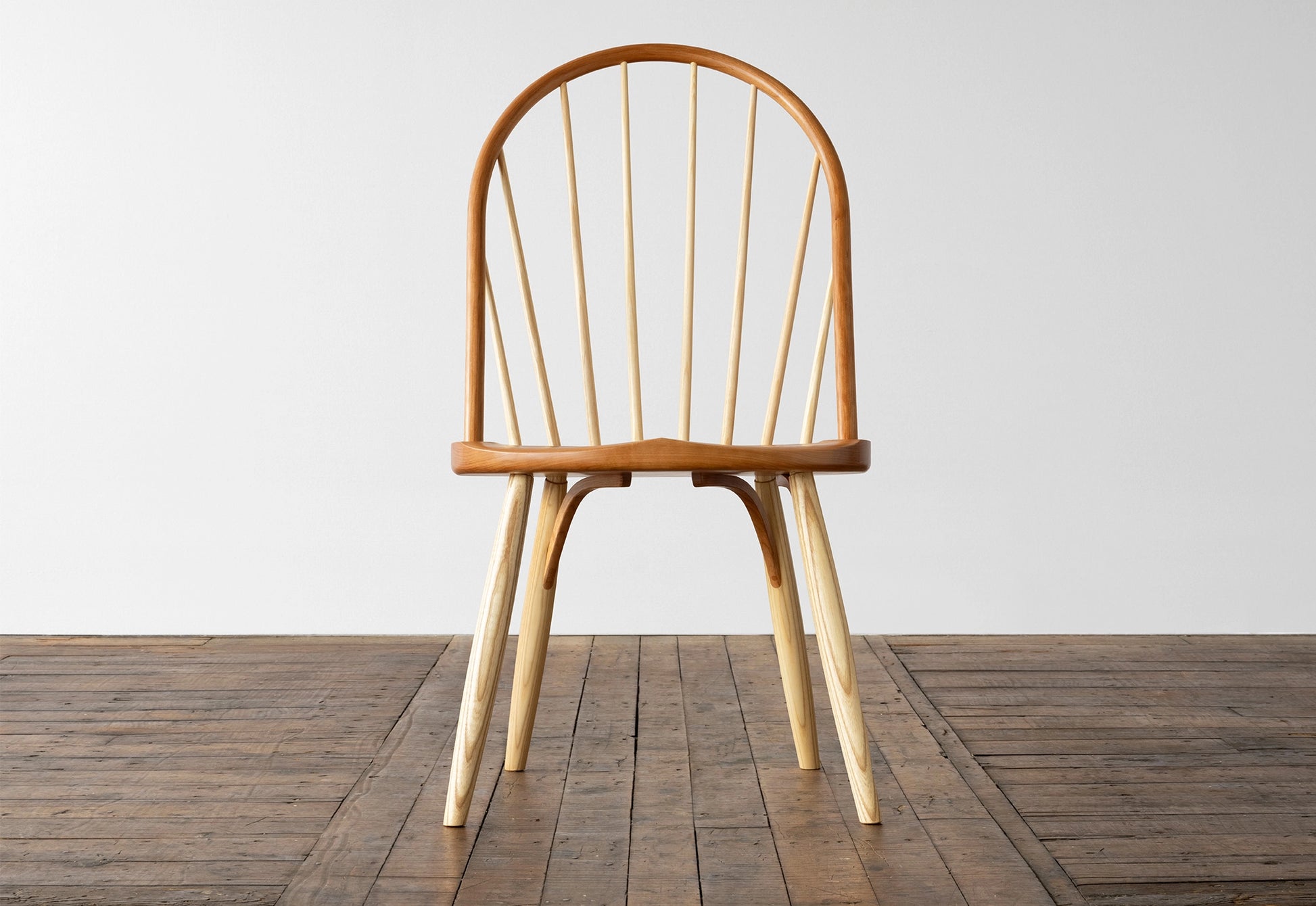 Wooden chair on a wooden floor with a white wall background