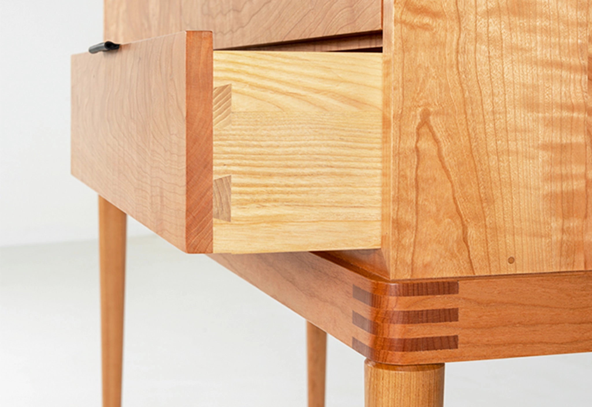 Wooden drawer unit with a light wood finish on a white background