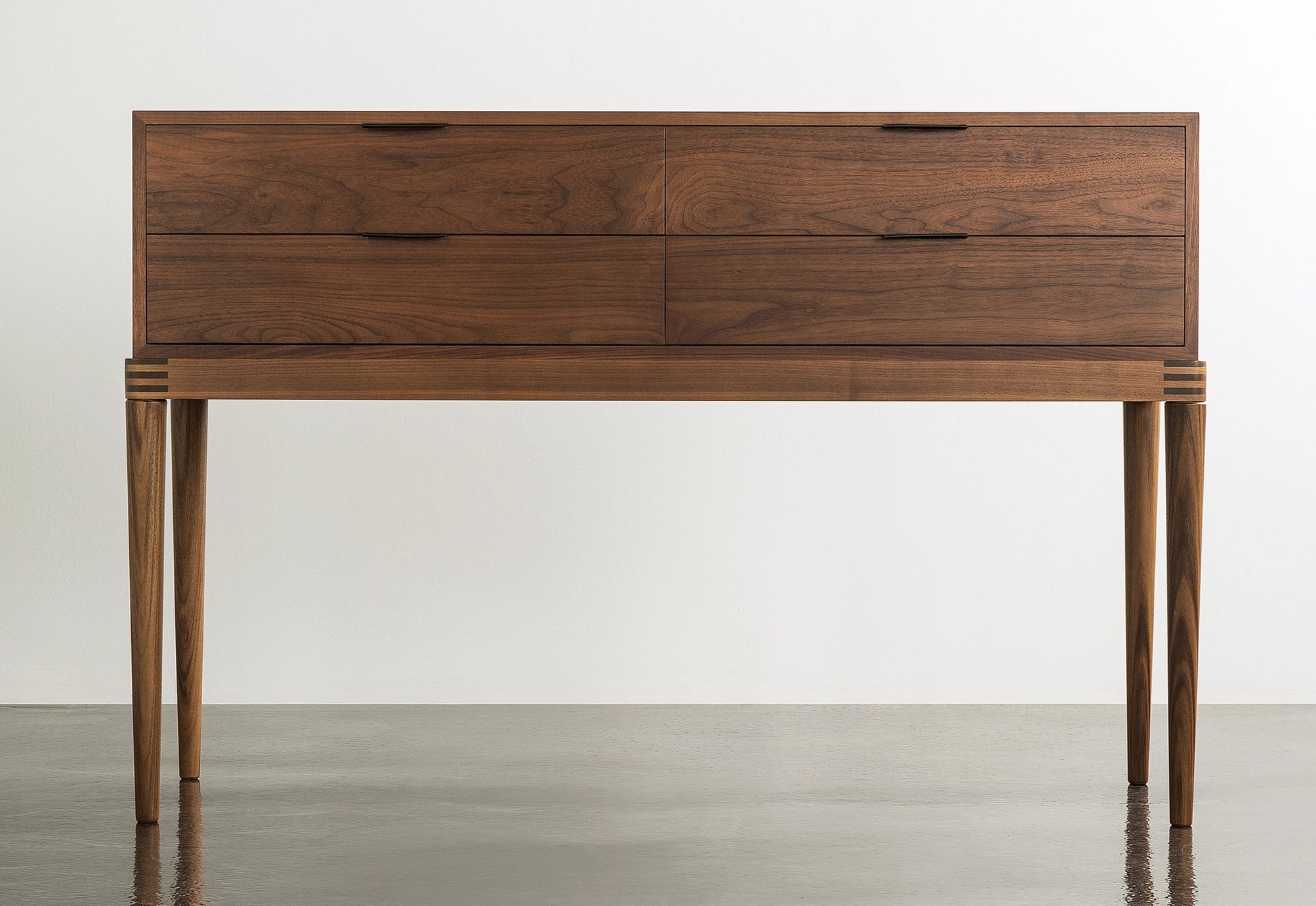 Wooden sideboard with multiple drawers on a plain background