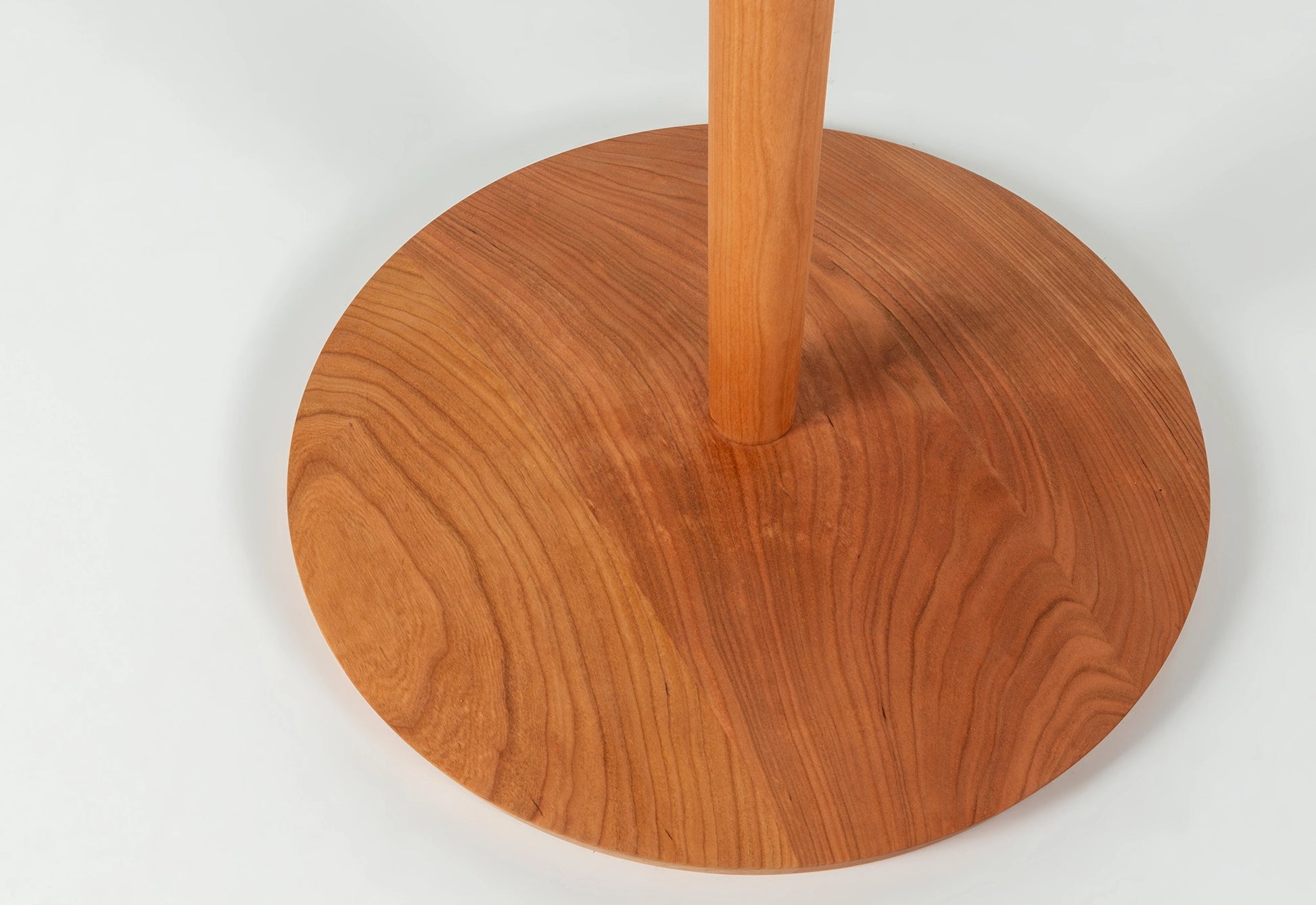 Base of a wooden coat tree on a white background.