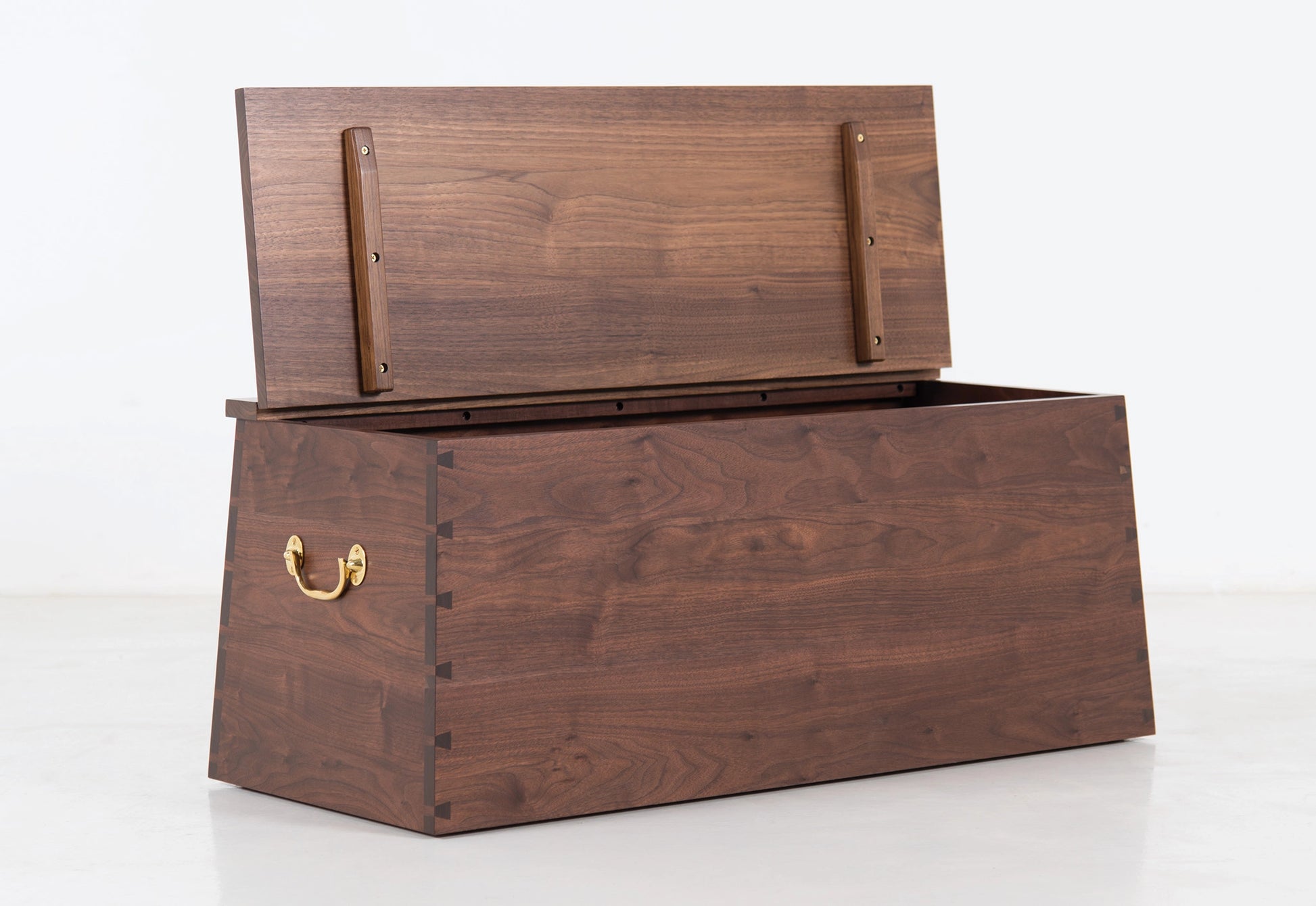 Wooden storage chest with a brass handle on a white background