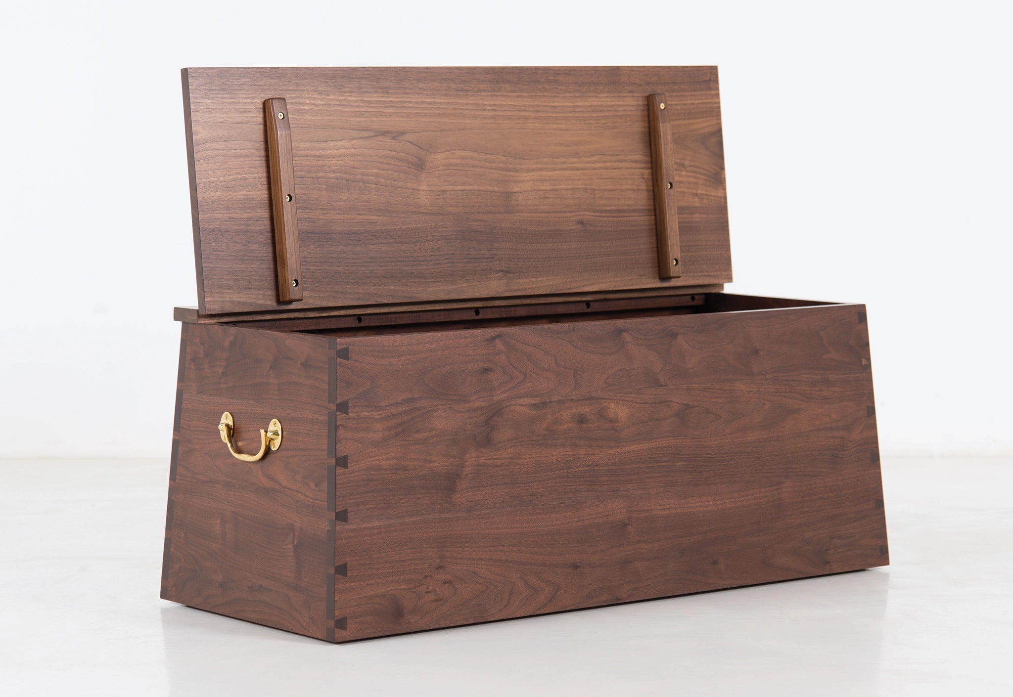 Wooden storage chest with a brass handle on a white background