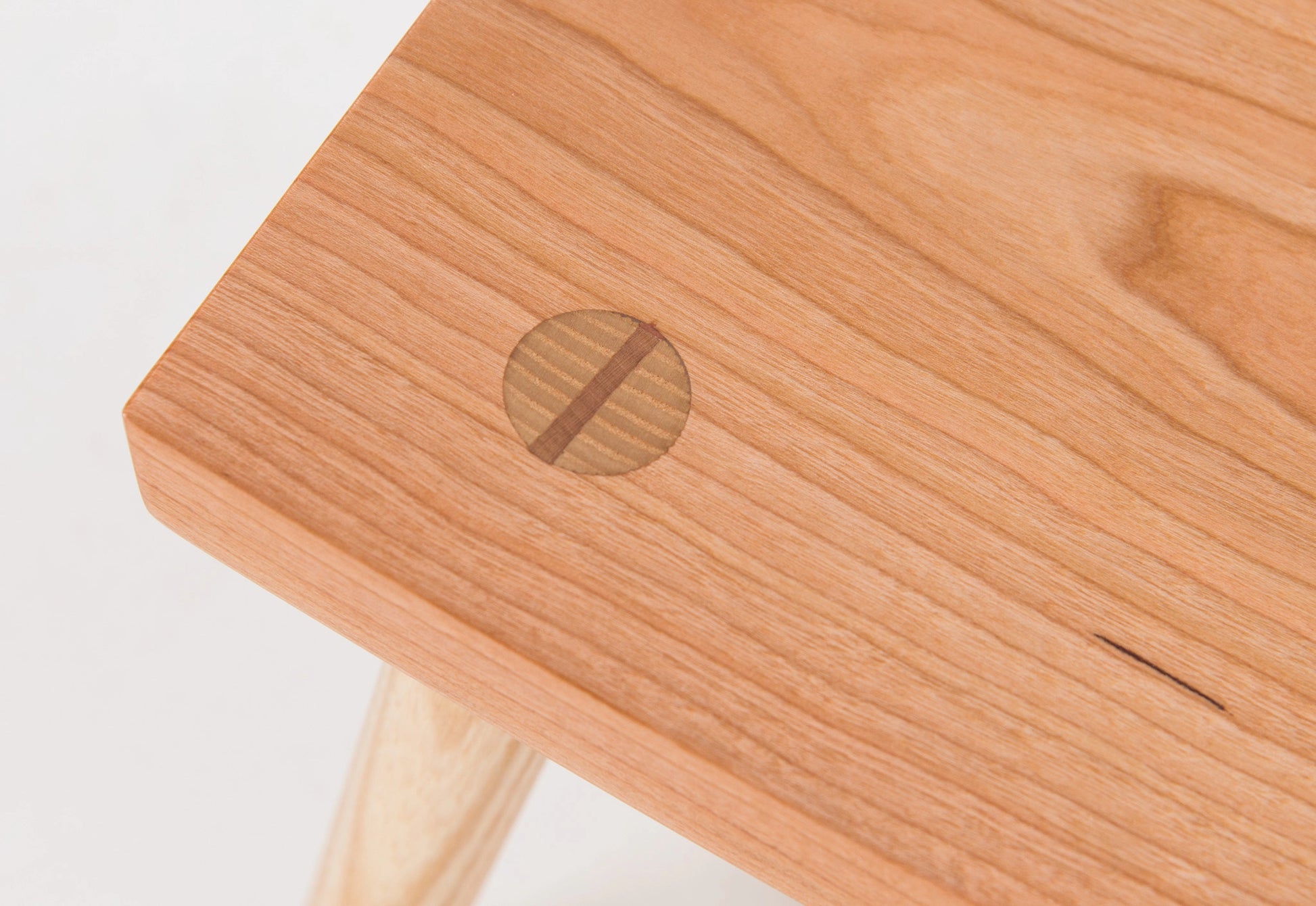 Wooden stool with visible joinery on a white background