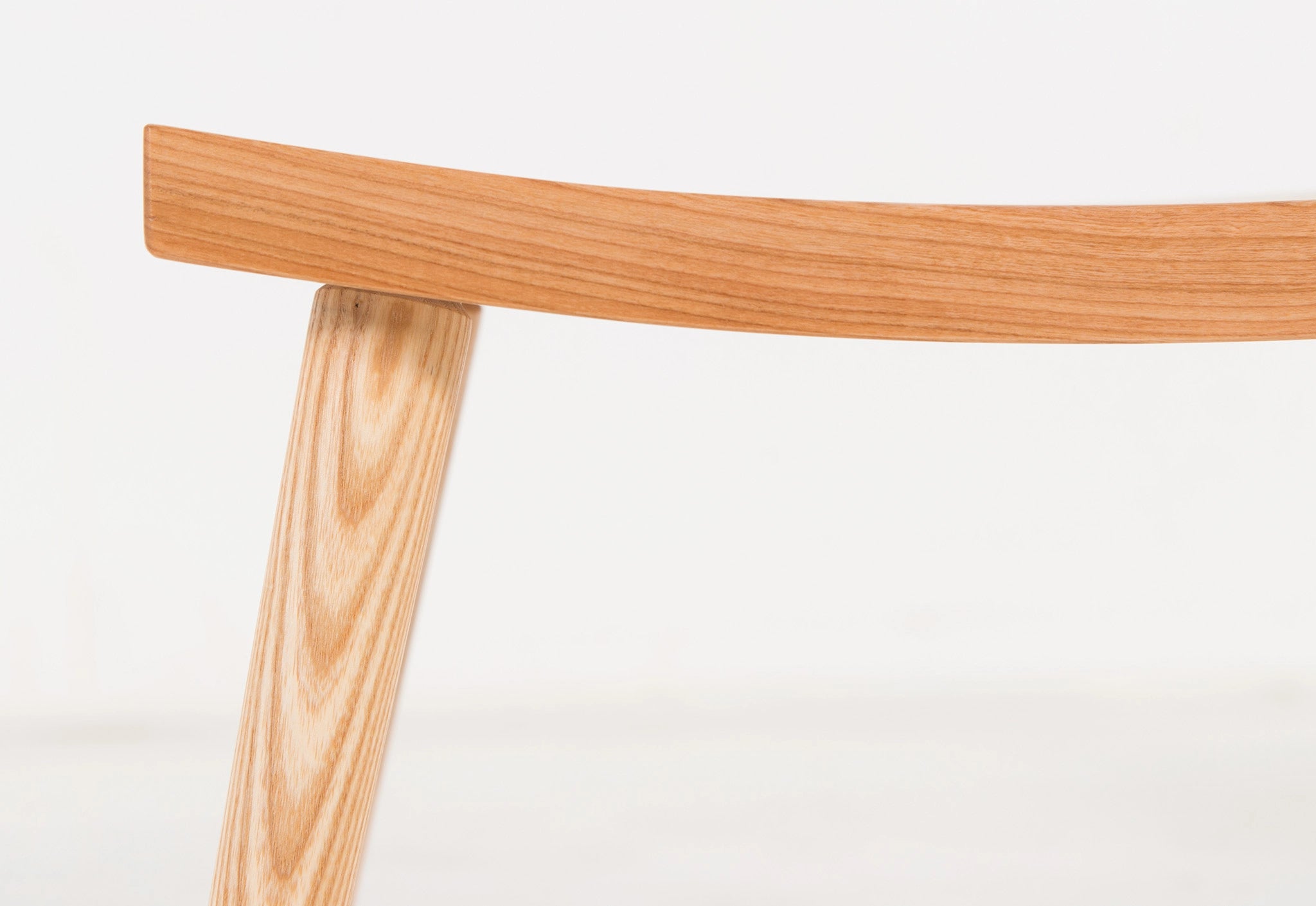 Close-up of a wooden stool with a light background