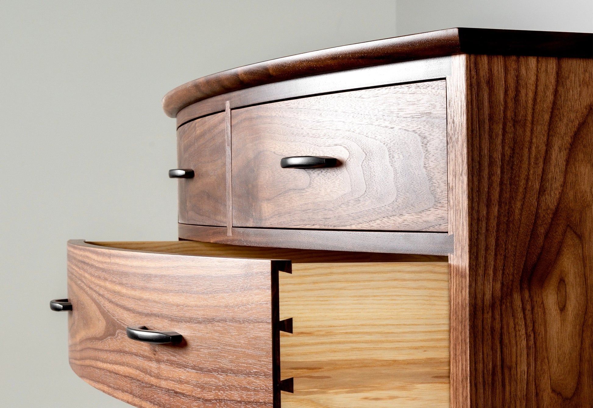 Wooden dresser with multiple drawers on a plain background