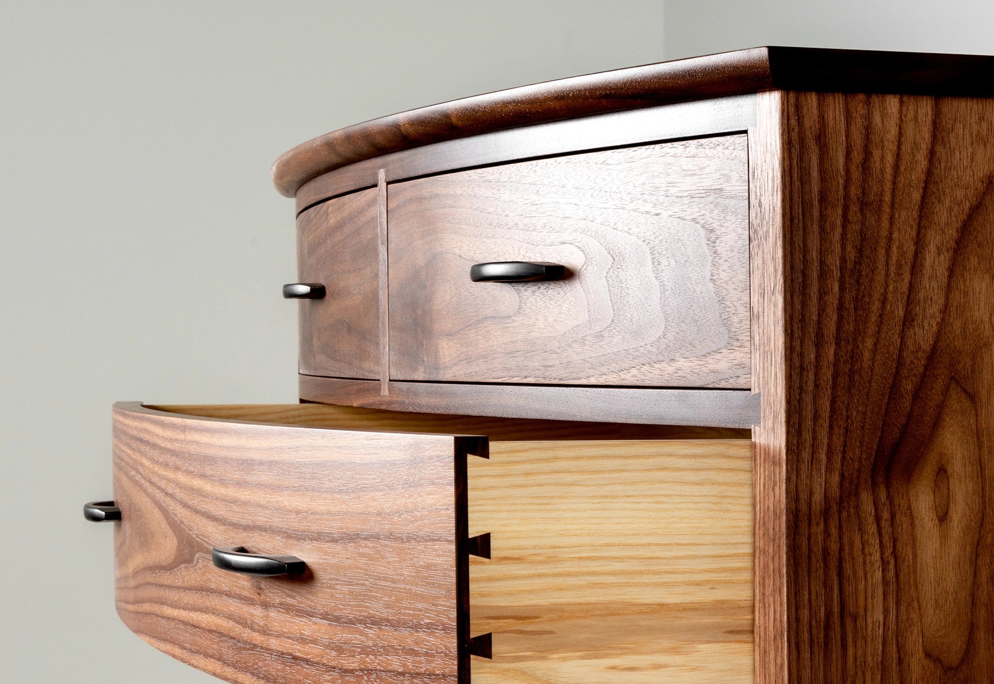 Wooden dresser with multiple drawers on a plain background