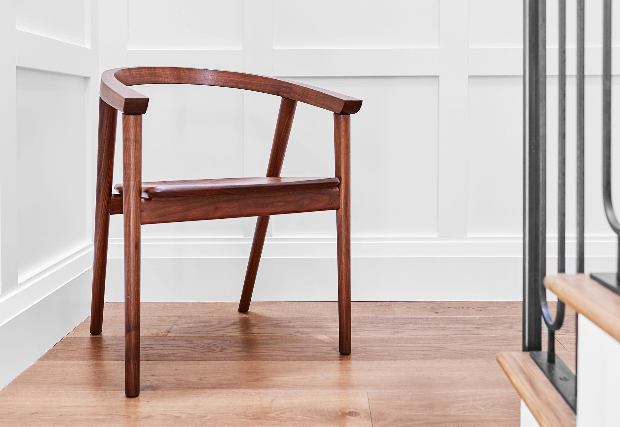 Wooden chair on a wooden floor with a white wall background