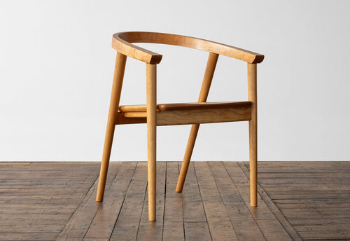 Wooden chair on a wooden floor with a white wall background