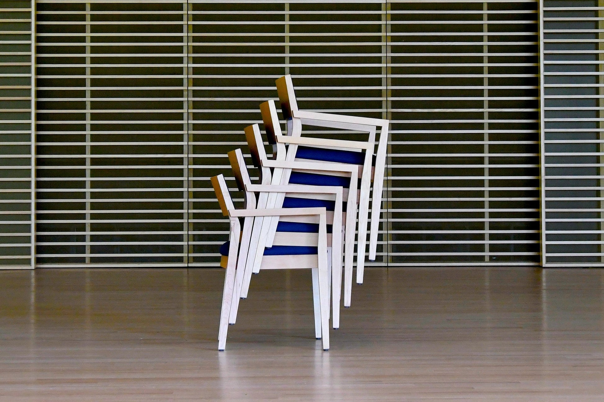 Stack of chairs against a wall with horizontal slats