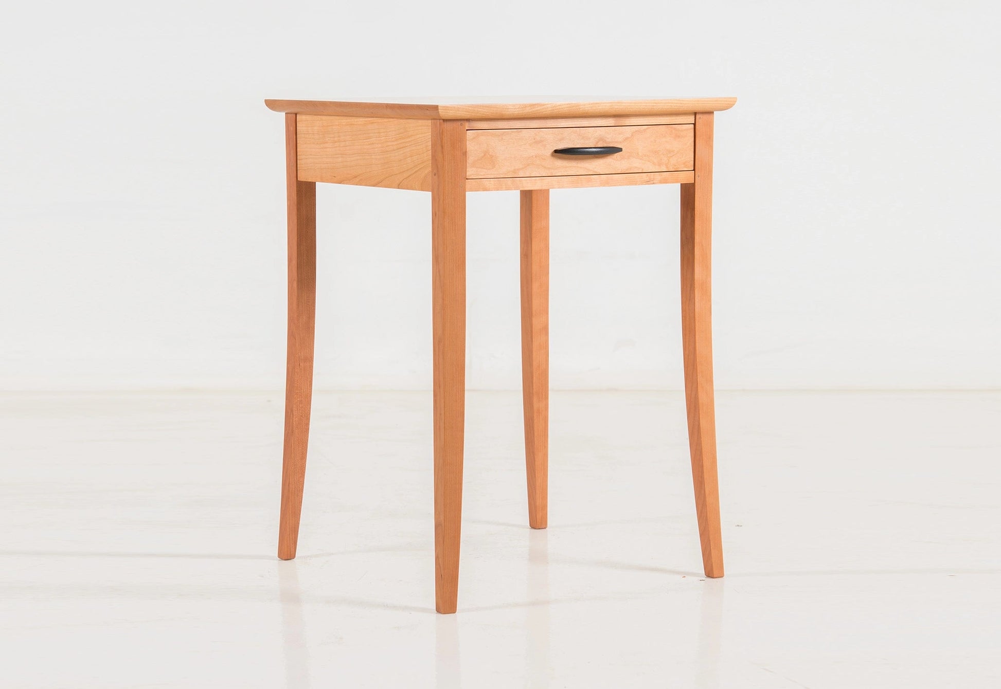 Wooden side table with a drawer on a white background