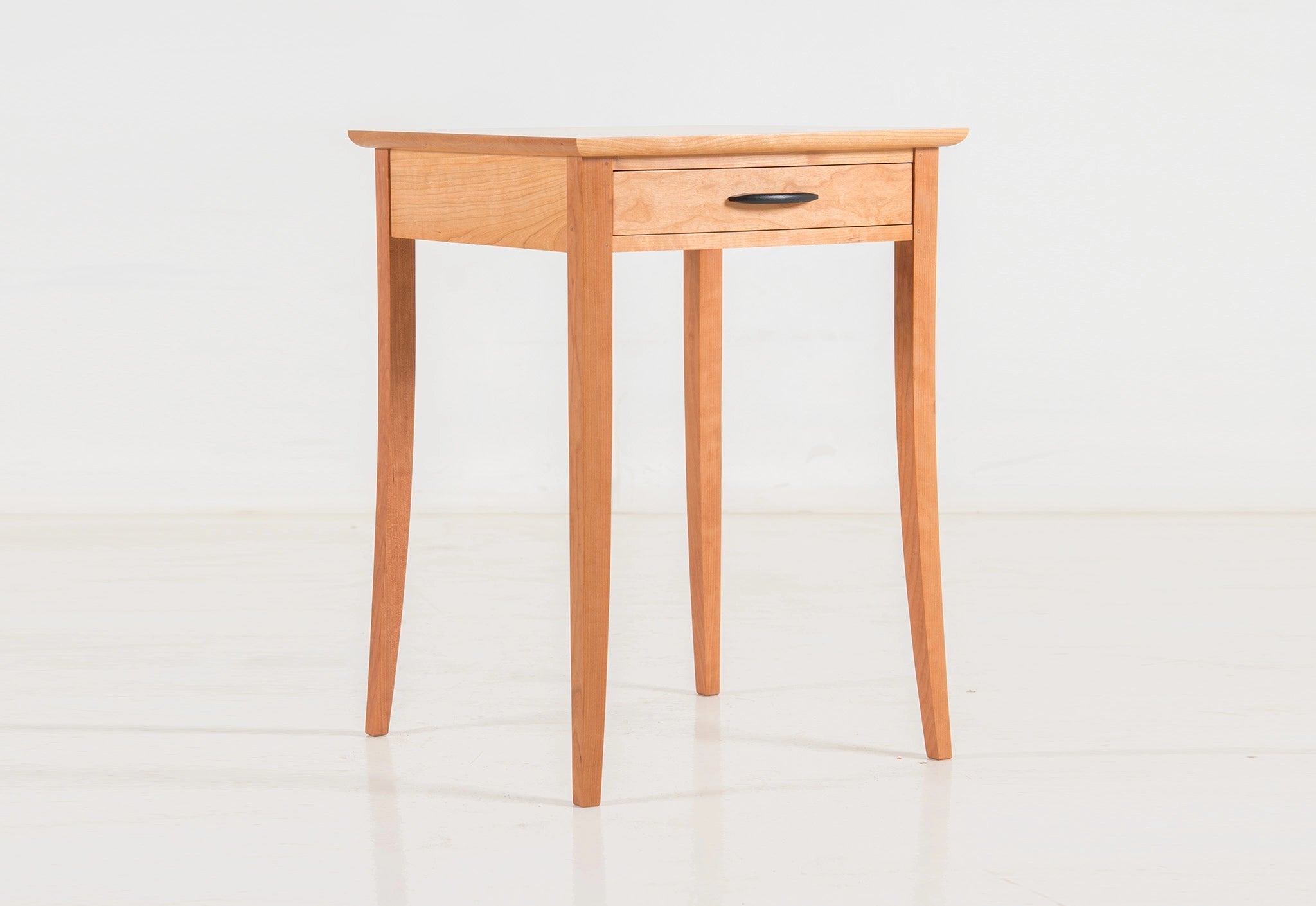 Wooden side table with a drawer on a white background