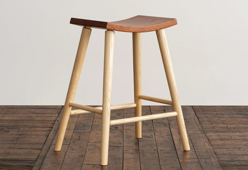 Wooden bar stool with a wooden seat on a wooden floor.