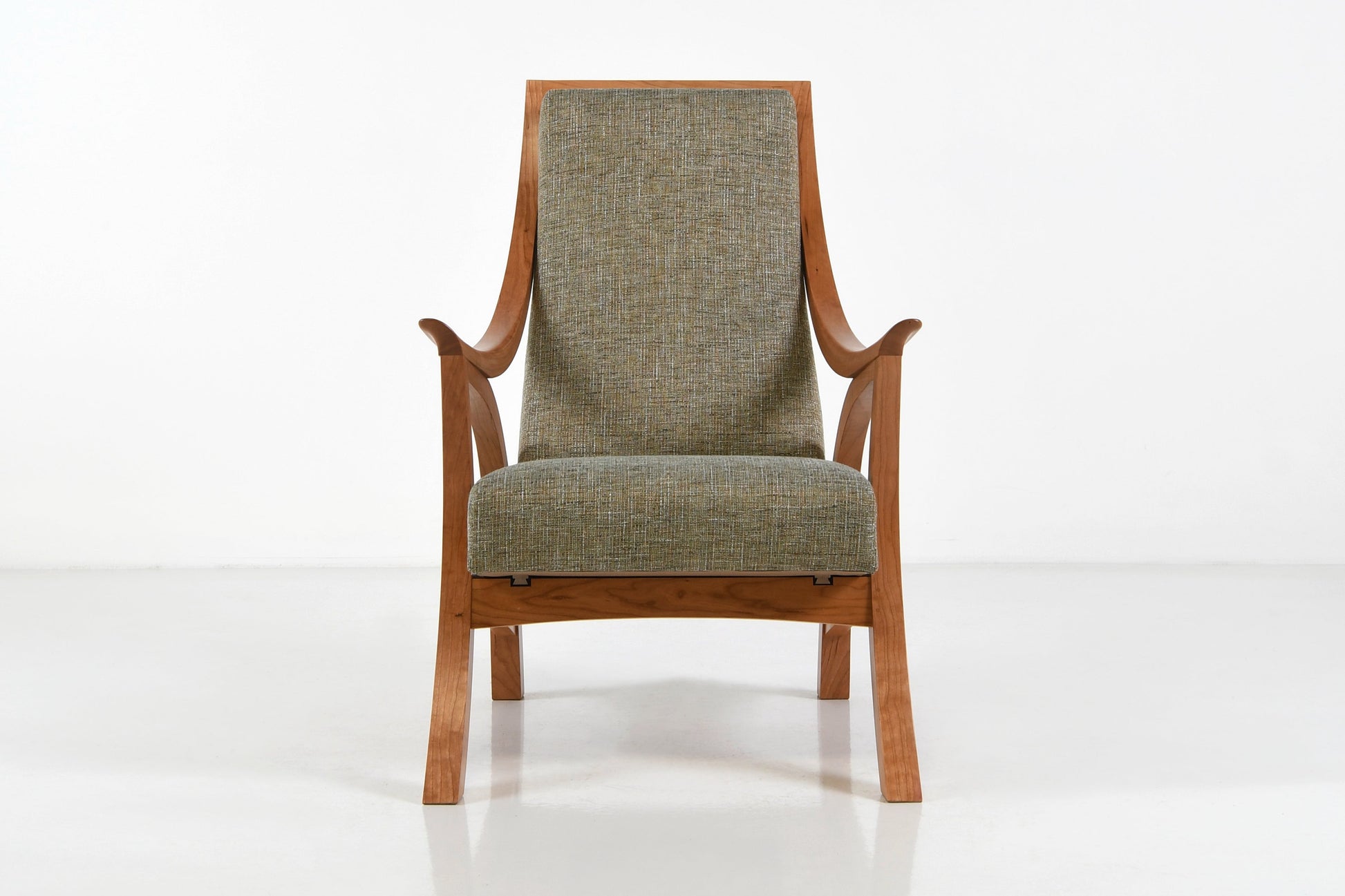 Chair with wooden frame and green cushion on a white background