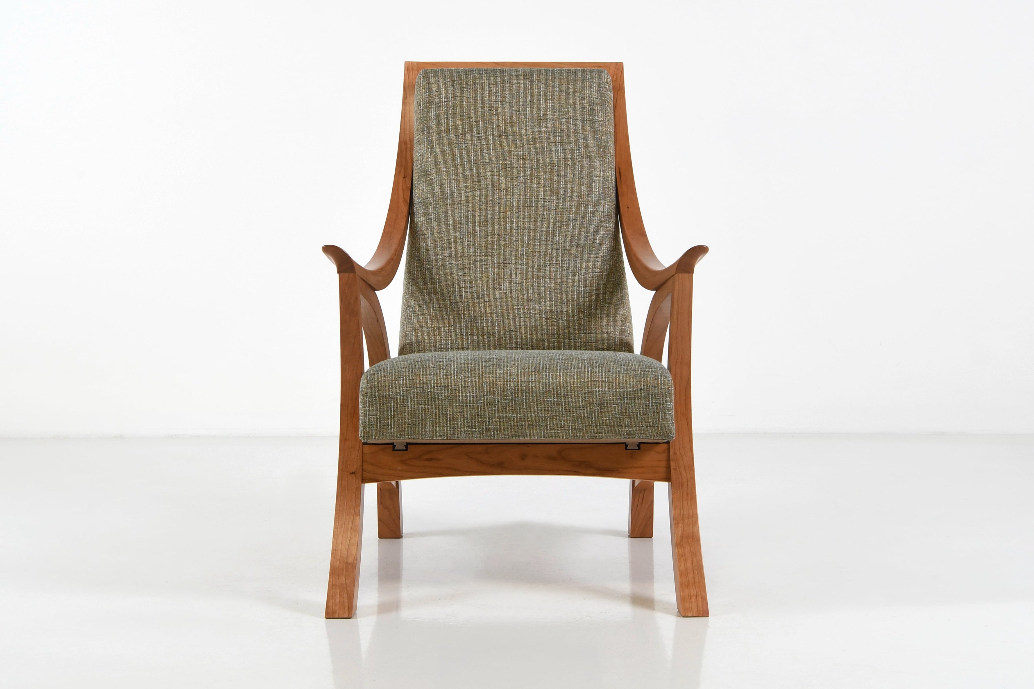 Chair with wooden frame and green cushion on a white background