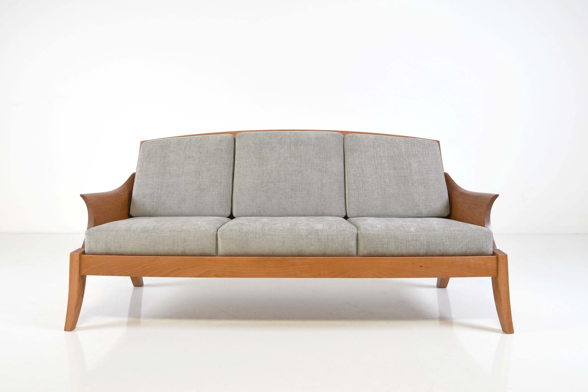 Sofa with wooden frame and light gray cushions on a white background
