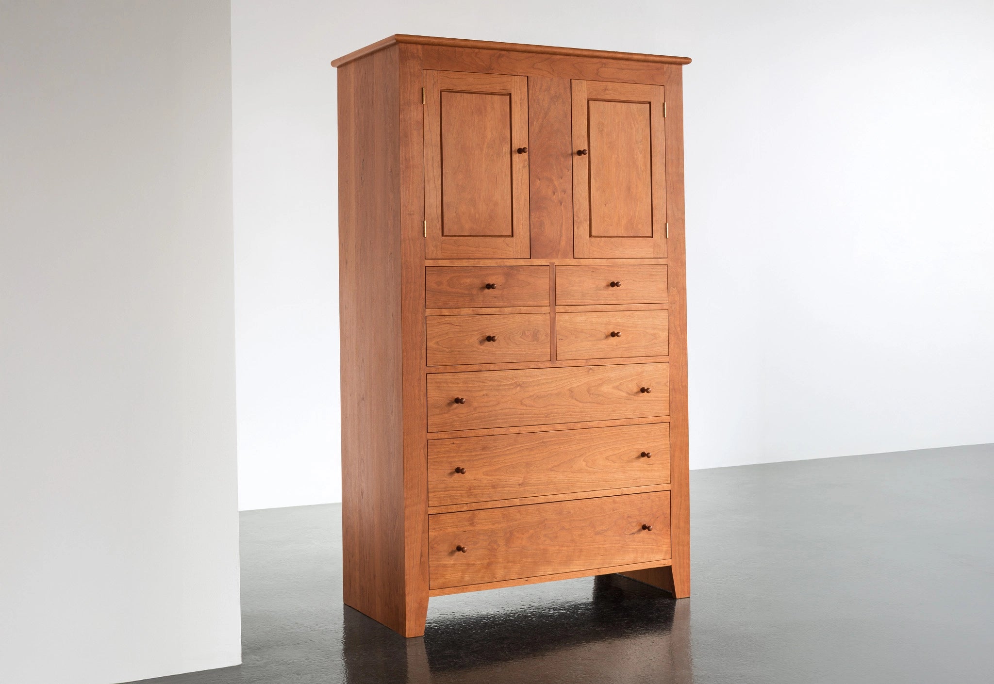 Wooden wardrobe with multiple doors and drawers on a white background