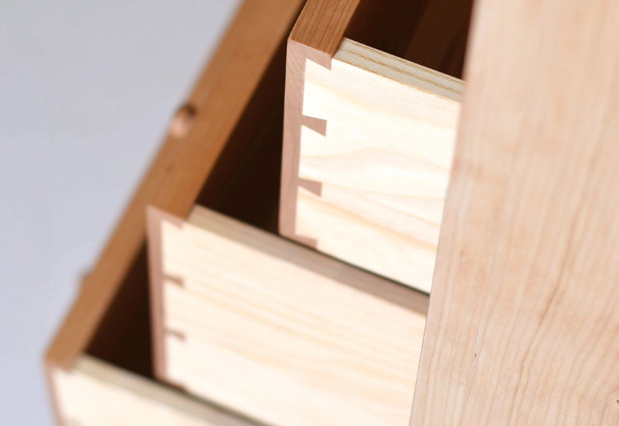 Wooden box with a lid open, revealing light-colored interior.