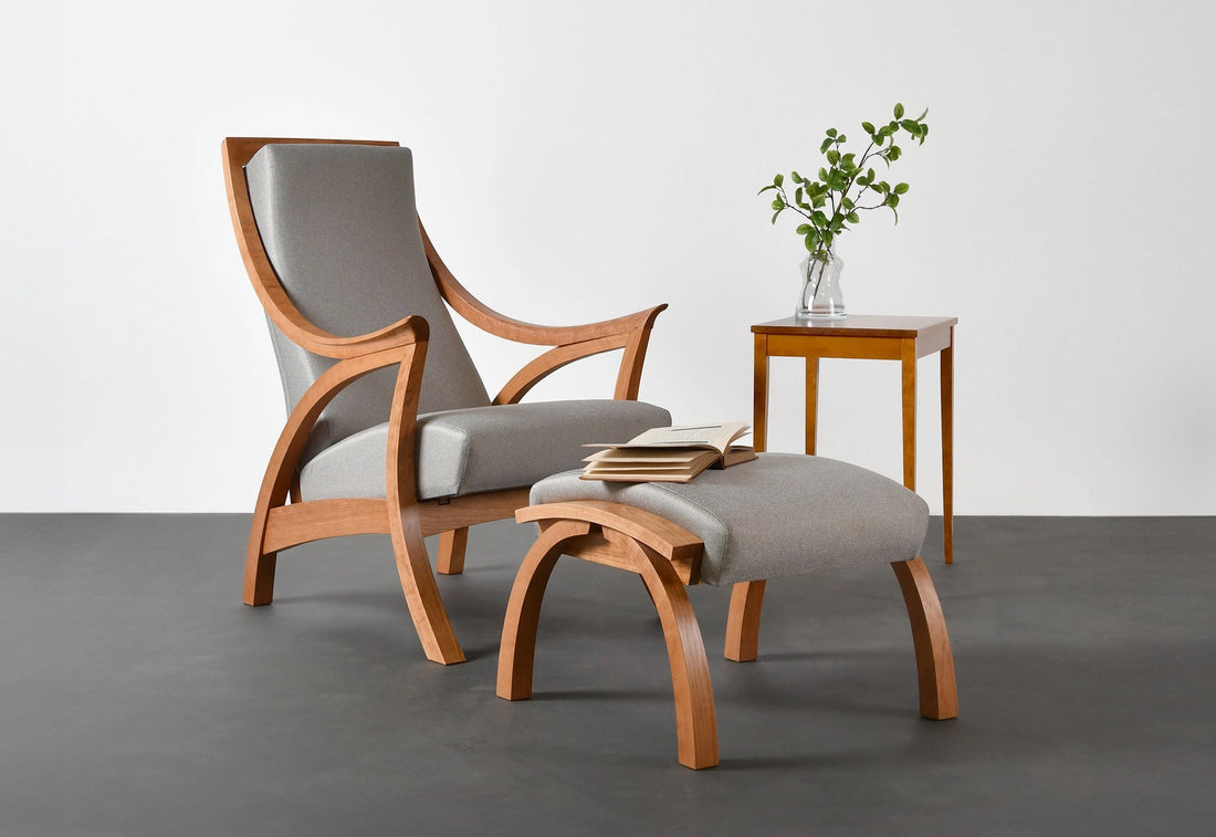 Wooden armchair with gray cushion and matching ottoman in a minimalistic room.
