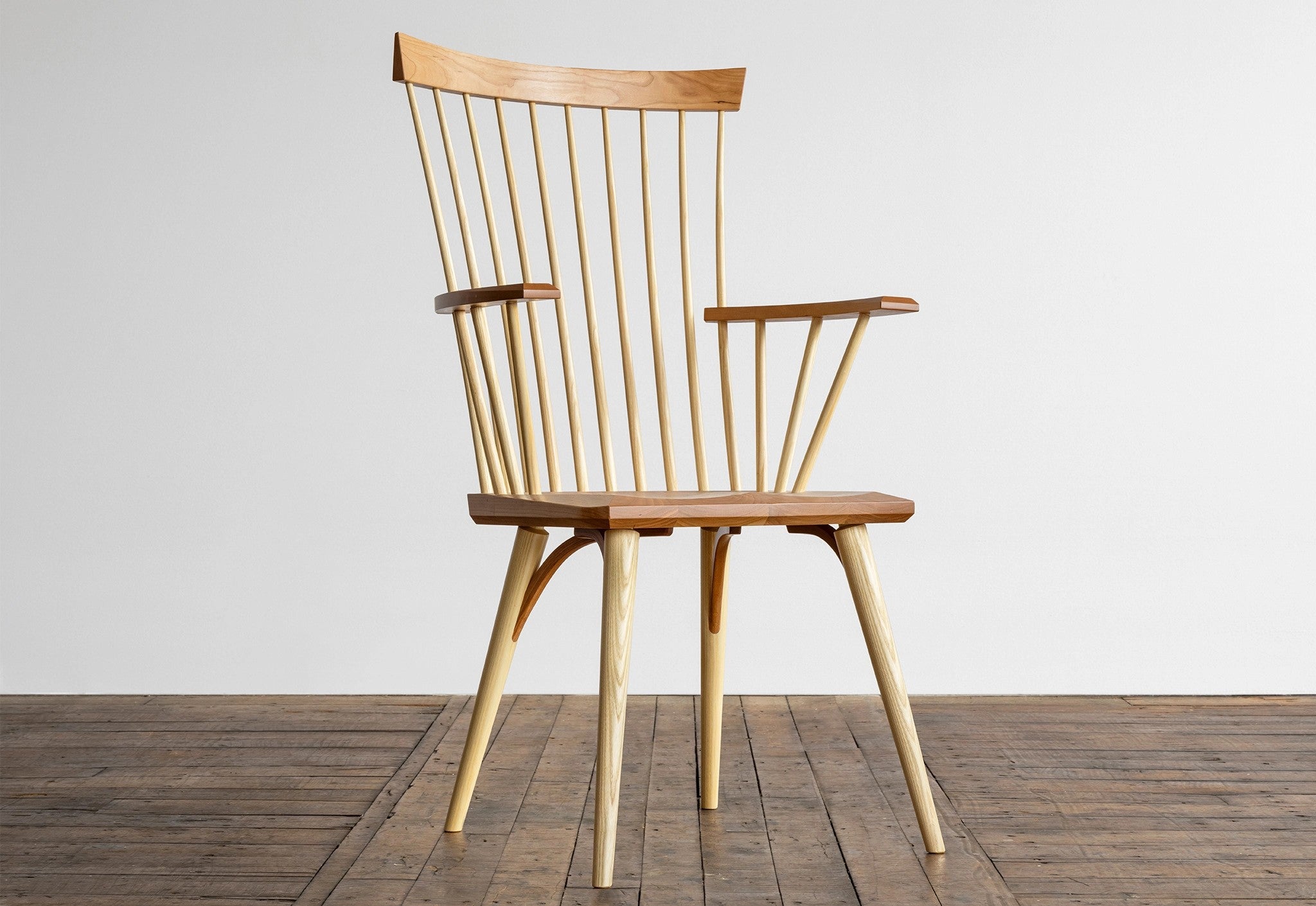 Wooden Arm Chair in Cherry on wooden floor and white background.