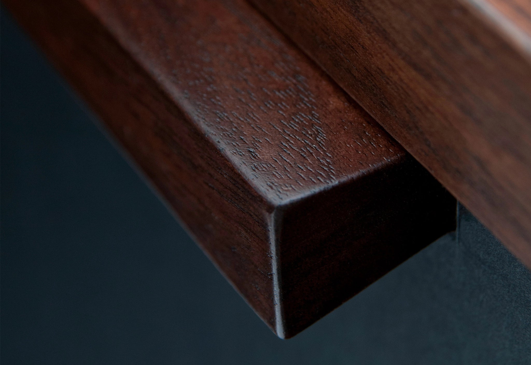 Close up of a wooden file case with black leather-faced drawers on a white background
