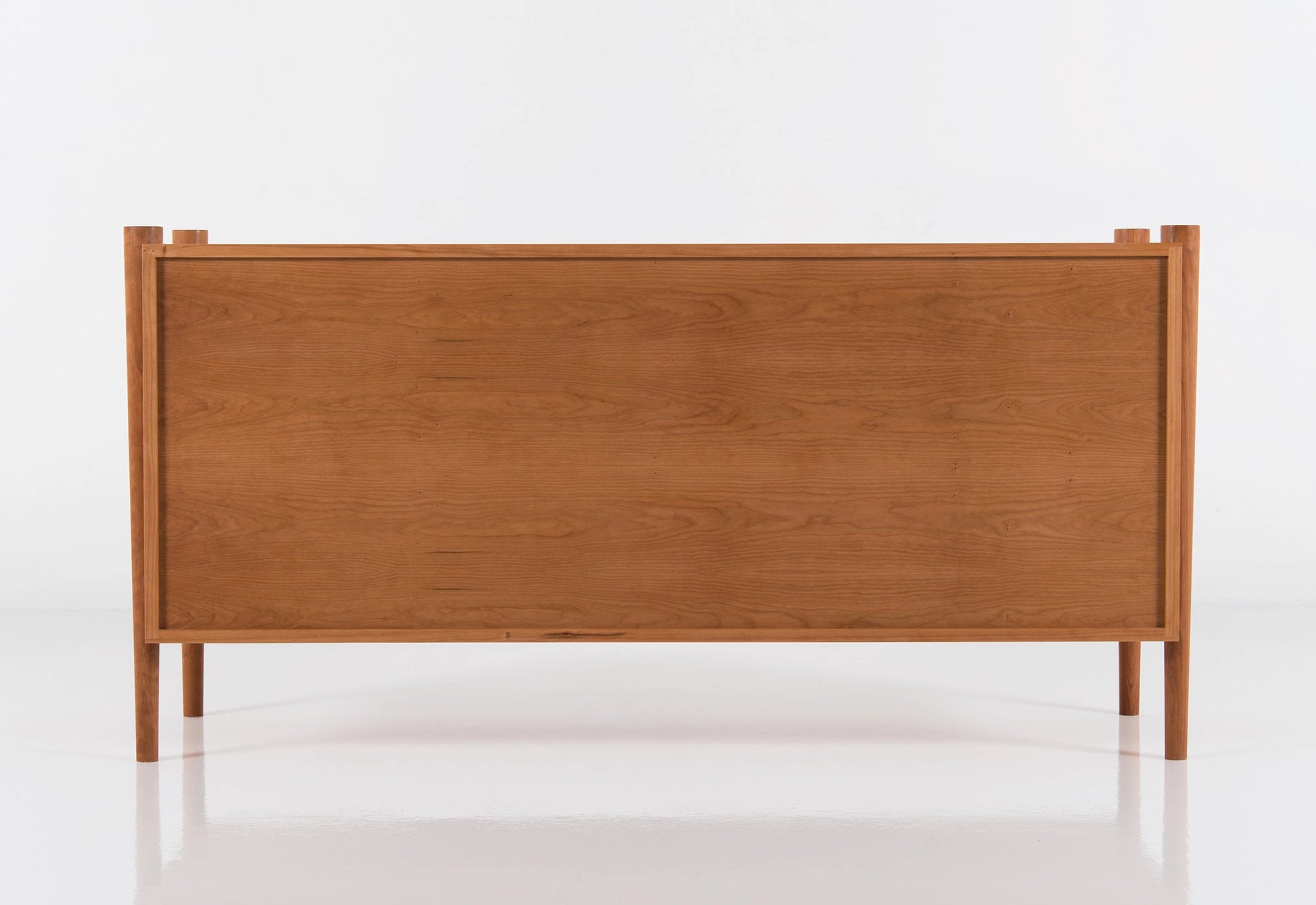 Back of a wooden dresser on a white background