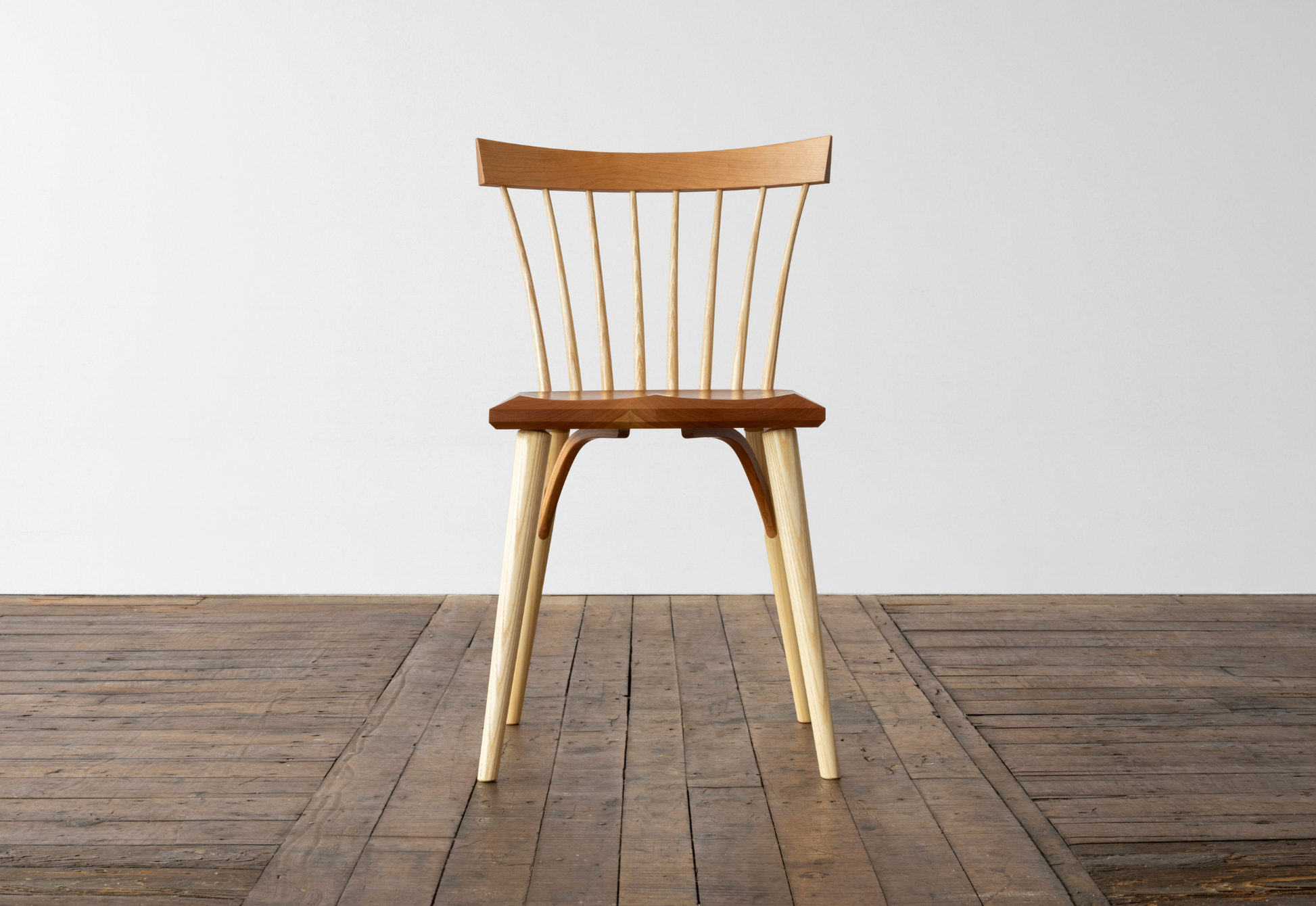 Wooden chair on a wooden floor with a white wall background